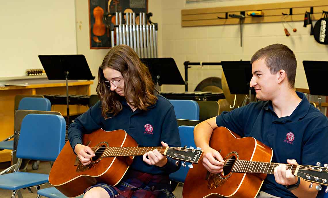 Students in music room playing guitar